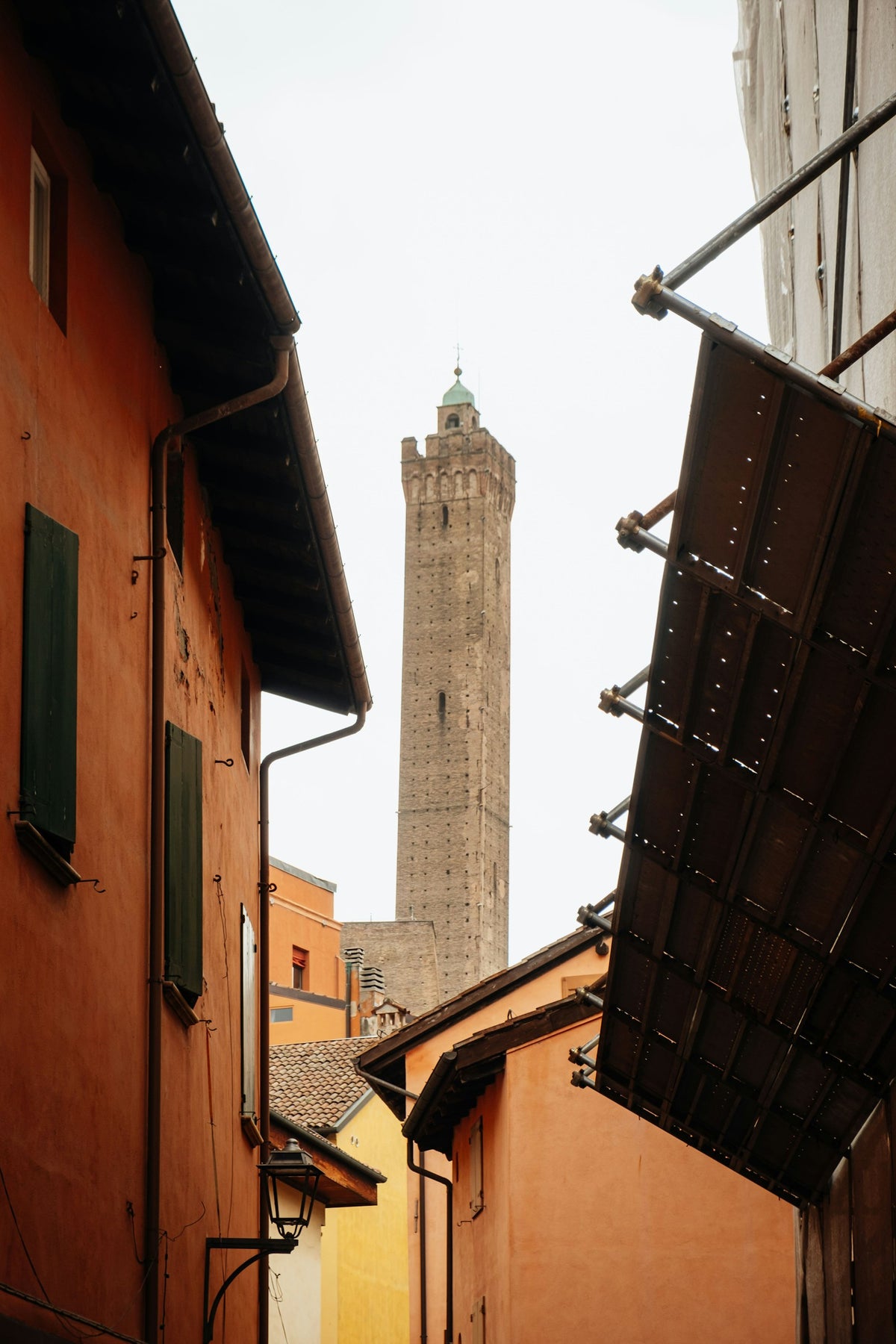 A tall medieval tower rising over the buildings of Bologna