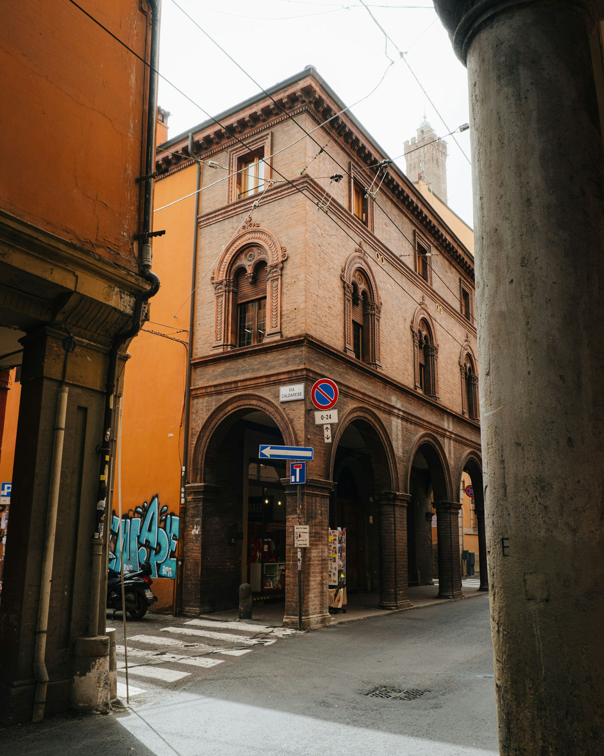 An old Bologna building with graffiti on its side