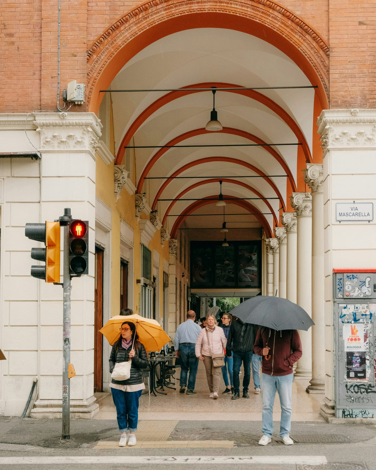 People walking down a Bologna street with umbrellas