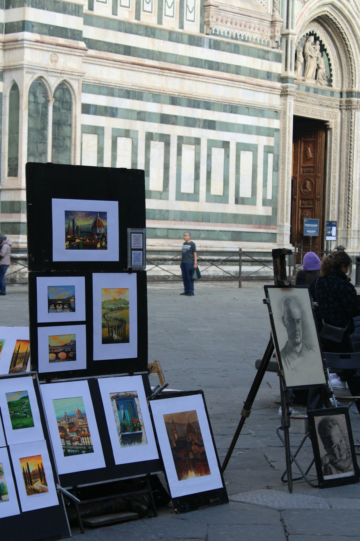 Street artists' paintings on display beside the Duomo