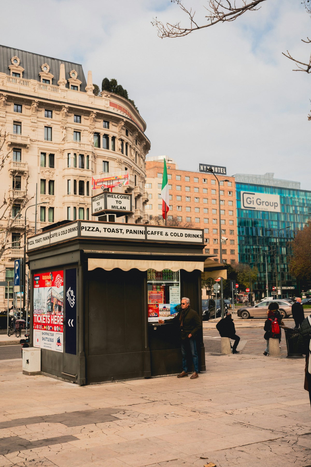 A Milan street scene with a newspaper kiosk