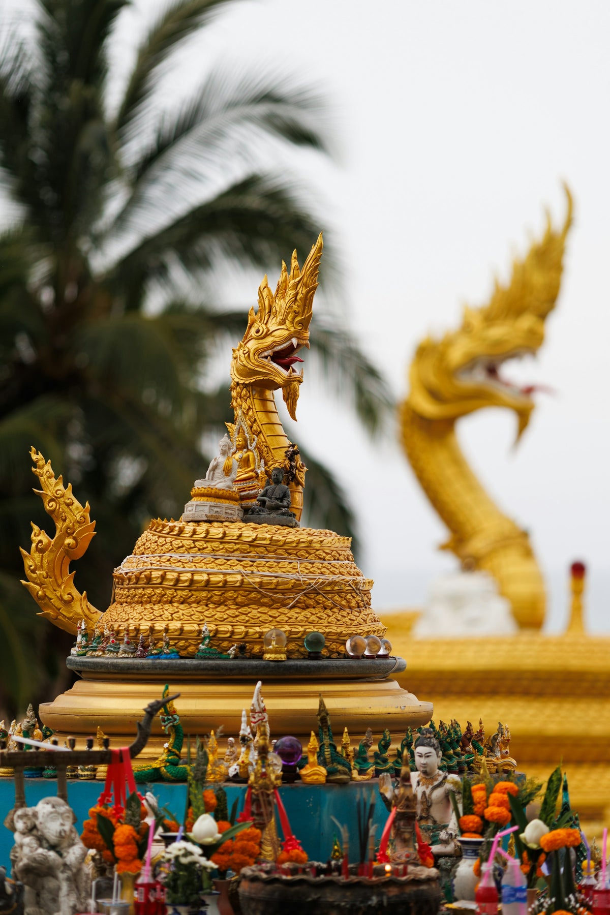 Golden naga statues on a shrine in Phuket