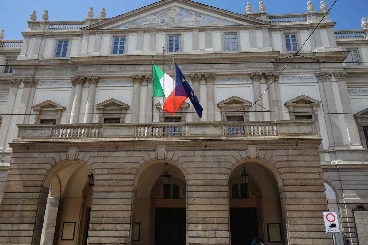 The façade of Teatro alla Scala with Italian and EU flags