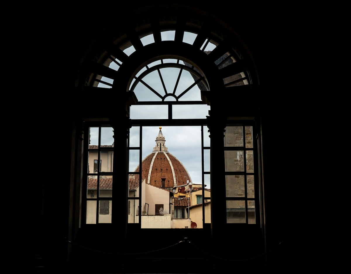 Brunelleschi's dome framed by a dark arched window