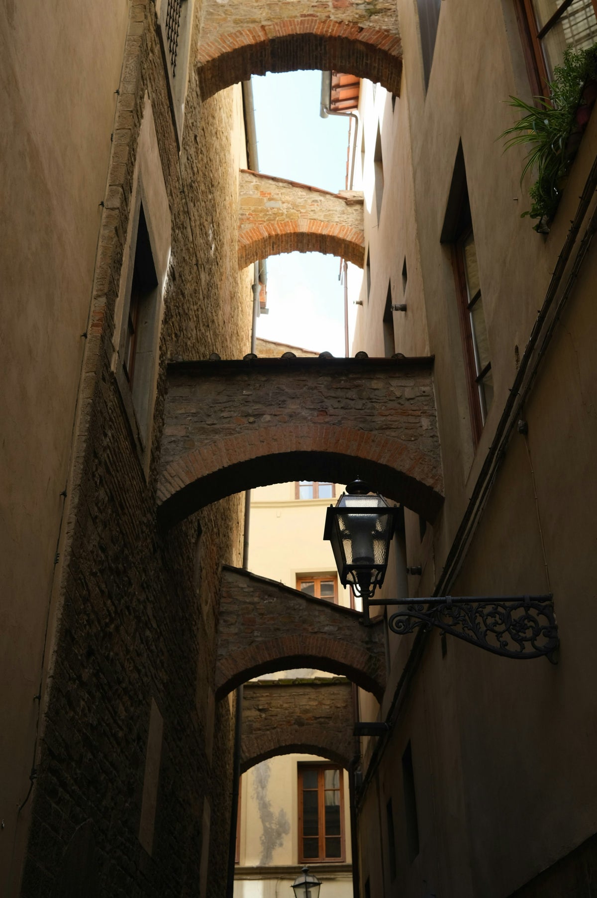 Brick arches linking buildings over a narrow medieval lane
