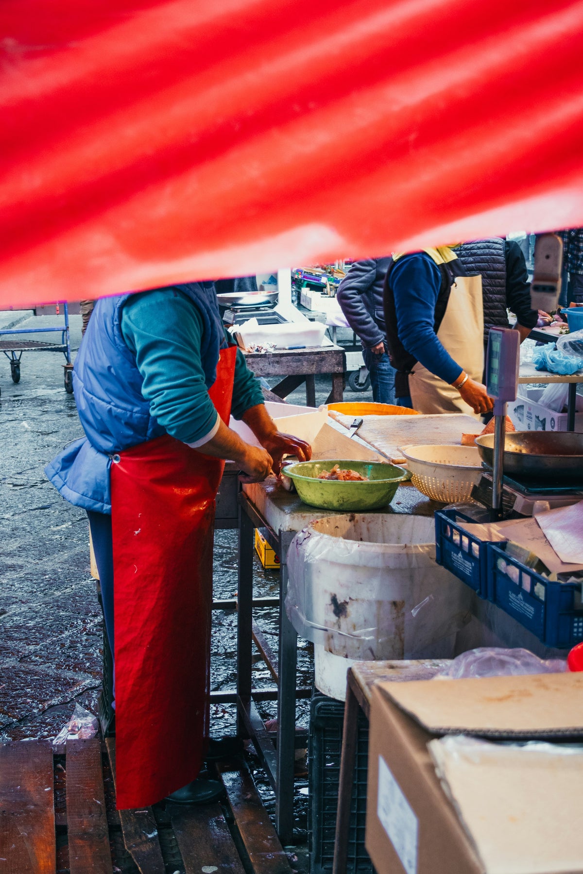 Preparing food under a red market awning