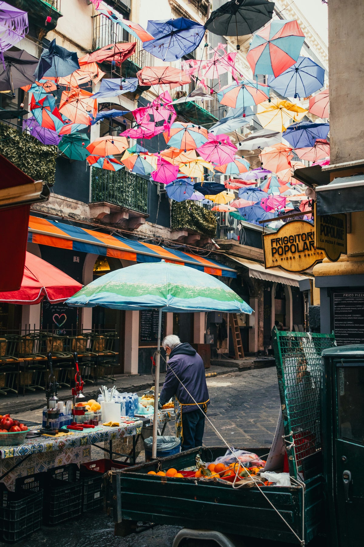 Colourful umbrellas over a fruit vendor's cart