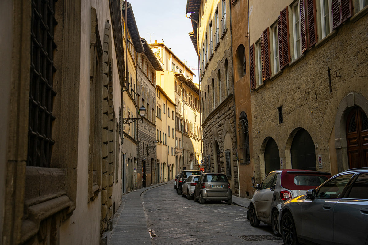 A quiet street of stone palazzi and parked cars