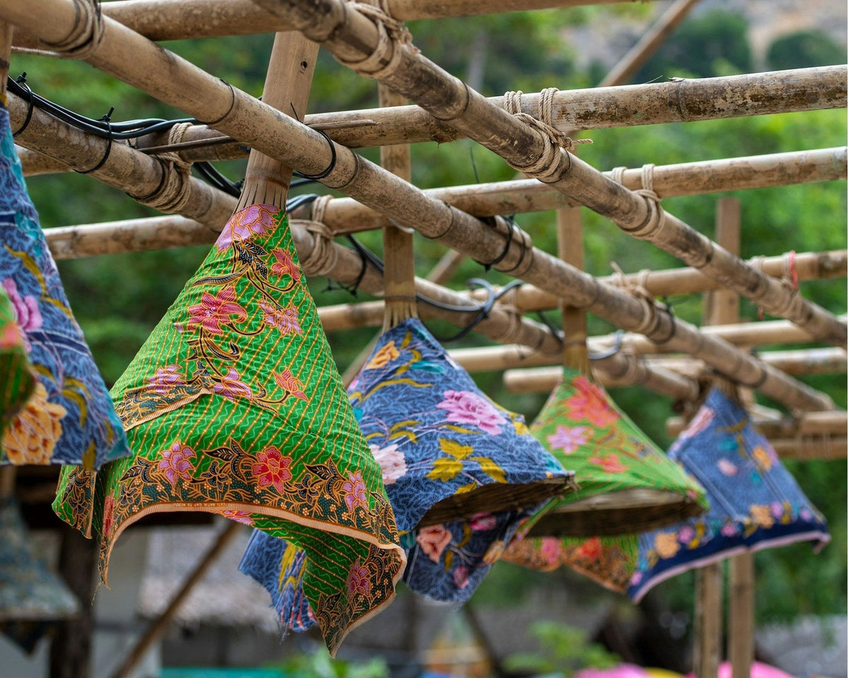 Colourful batik covers hanging from bamboo frames in Krabi
