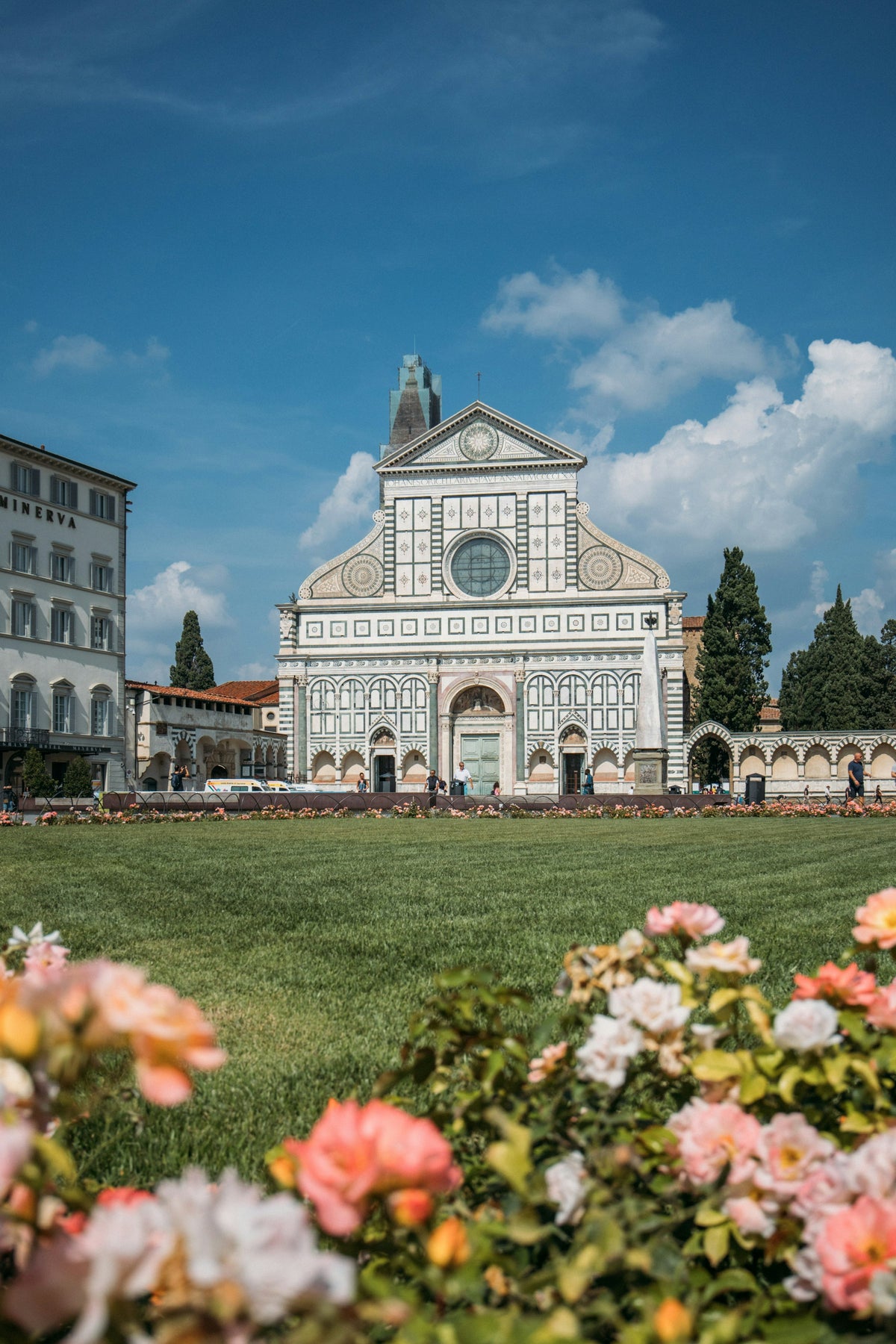 Santa Maria Novella's facade above its lawn and flowerbeds