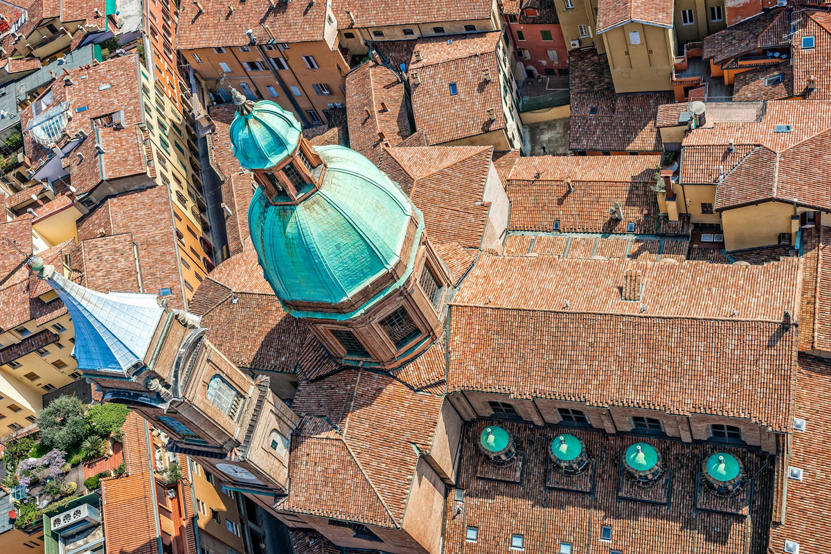 Bologna's rooftops from above, with a prominent green dome