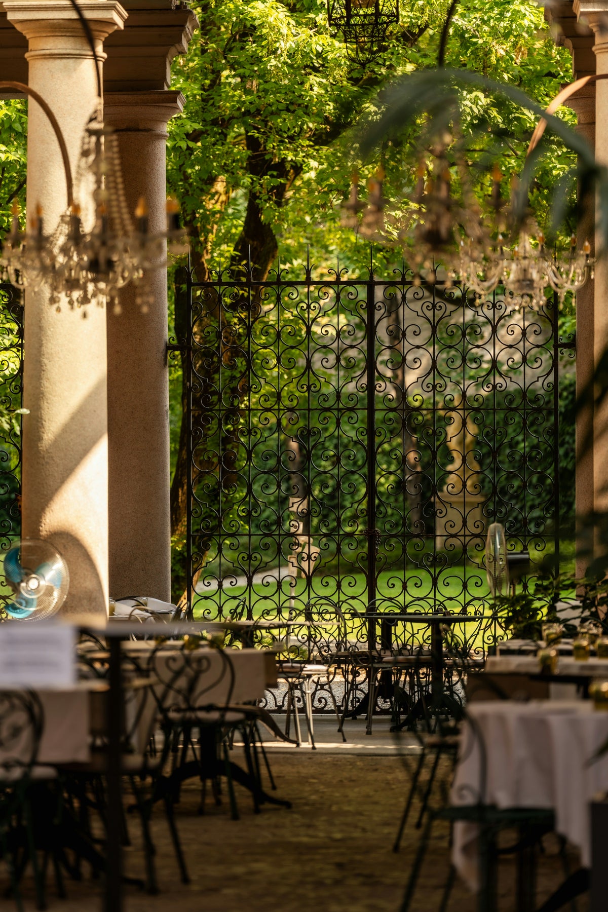 An outdoor dining garden with chandeliers in Milan