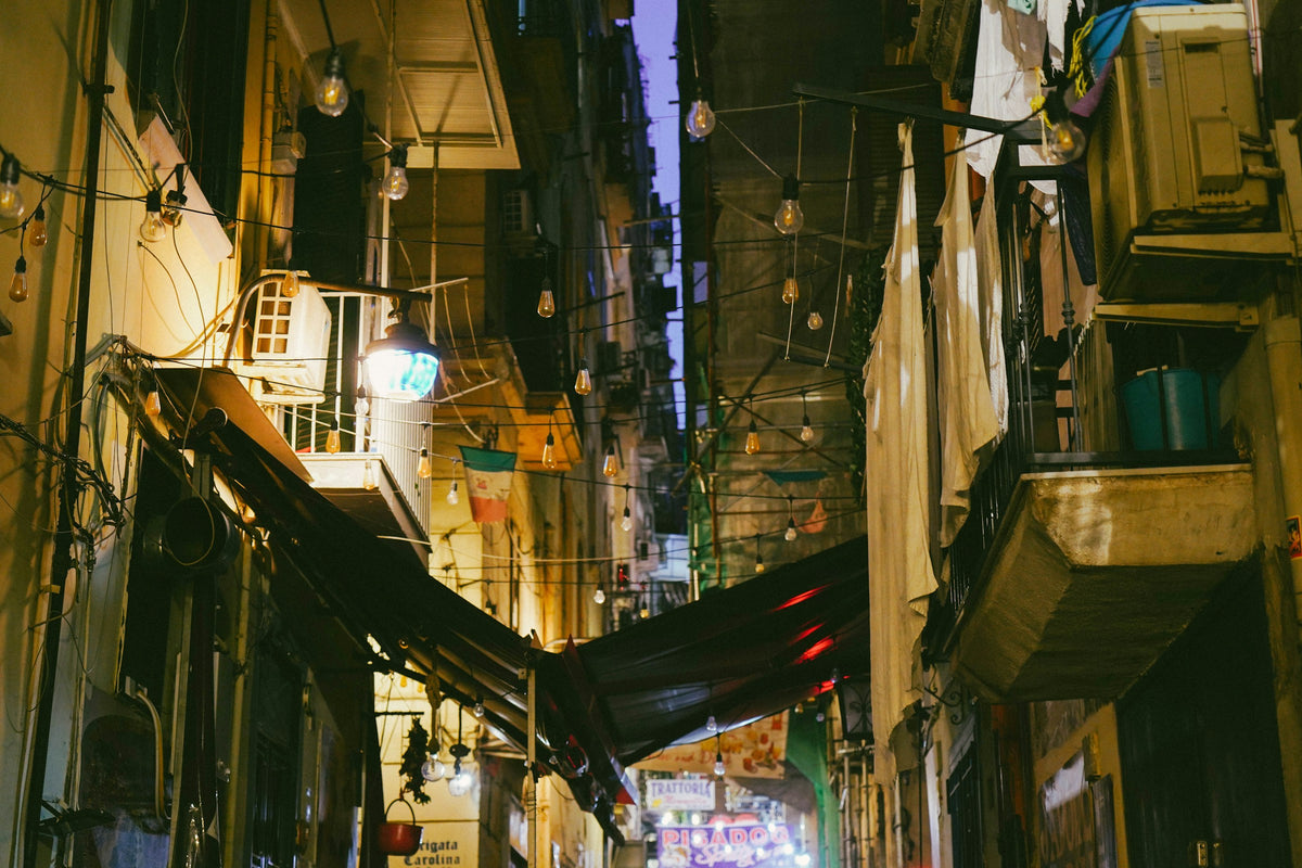 A Naples alley at night under string lights