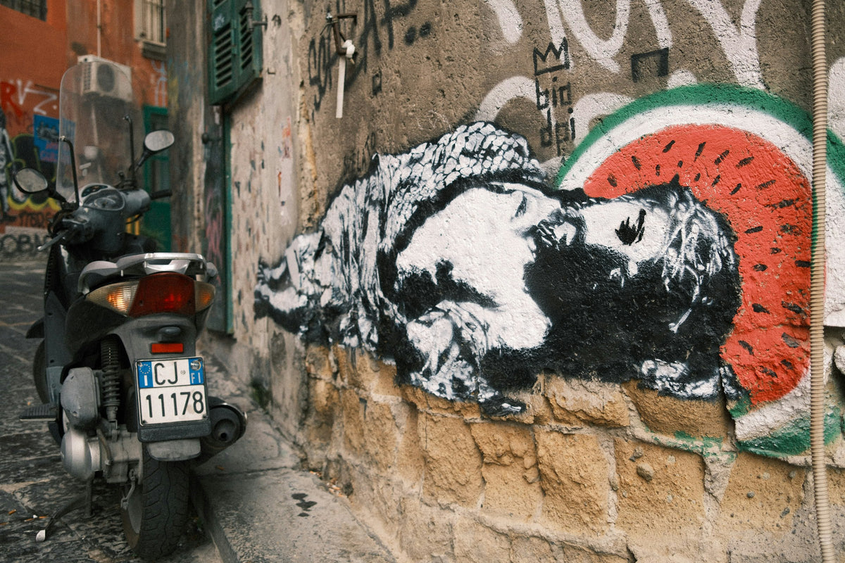 A parked scooter beside street art
