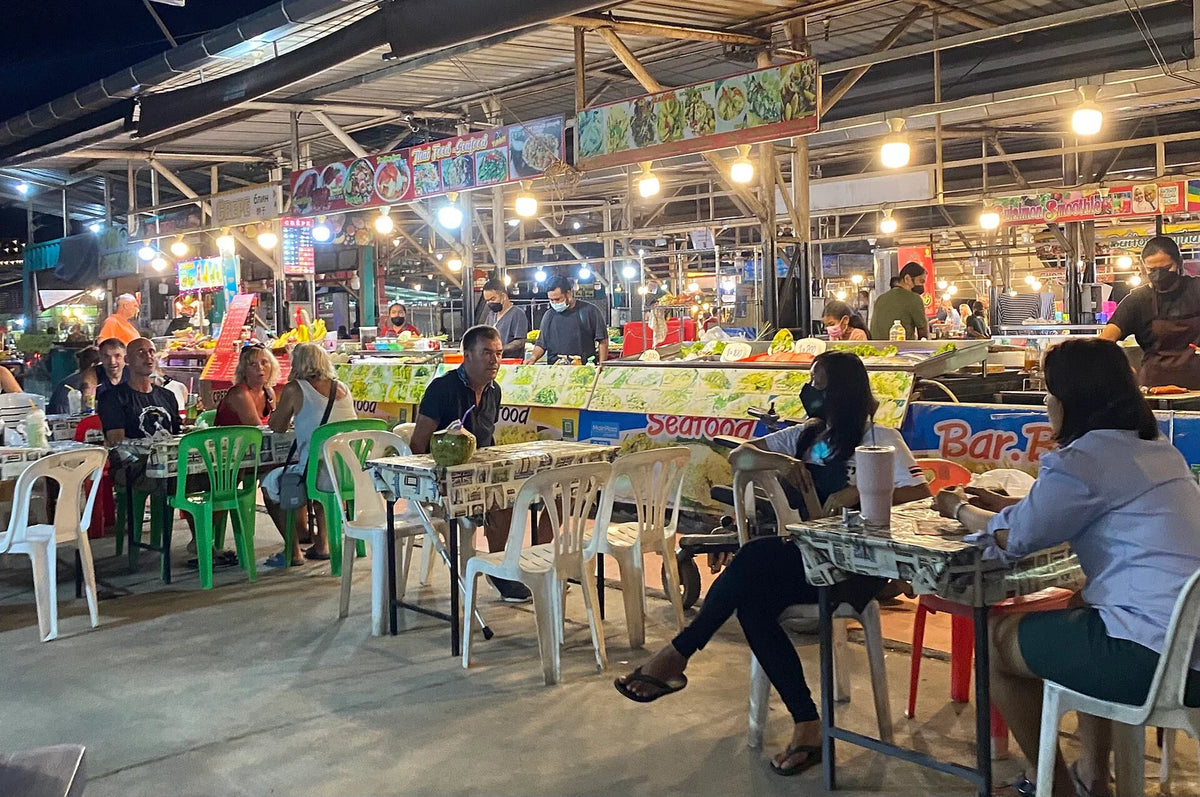 Diners and lit food stalls at a Phuket night market