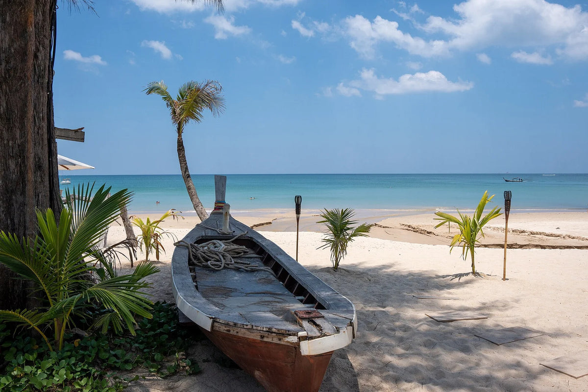 A traditional boat on the pale sand of Bang Tao Beach