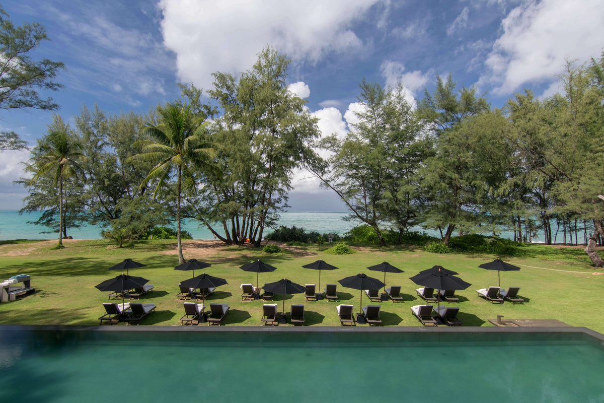 Beachfront pool and loungers on Mai Khao Beach at SALA Phuket