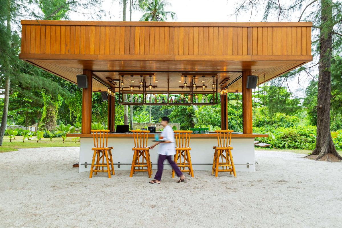 Wooden beach bar under casuarina trees at SALA Phuket