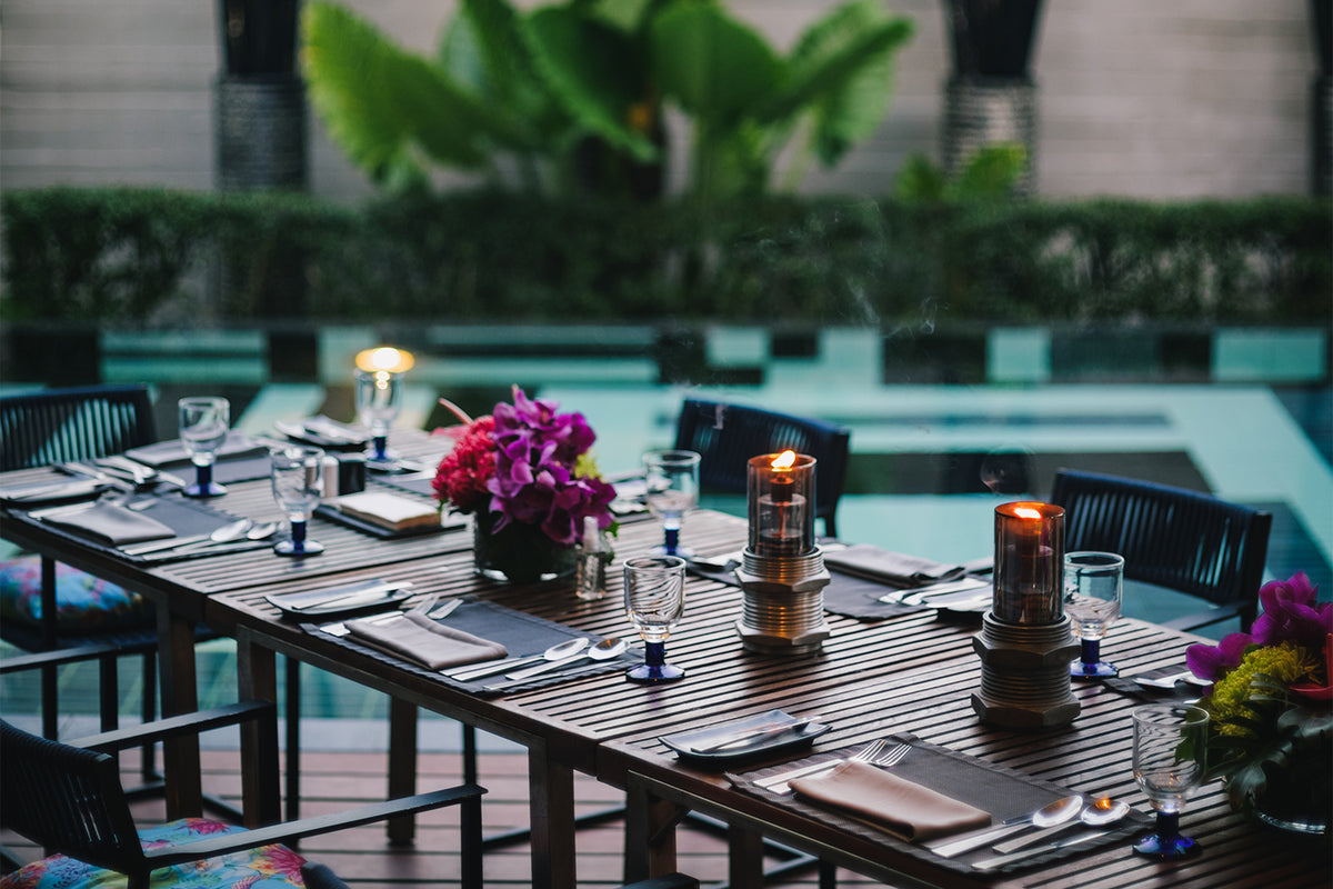 Candlelit private dining table by the pool at The Slate