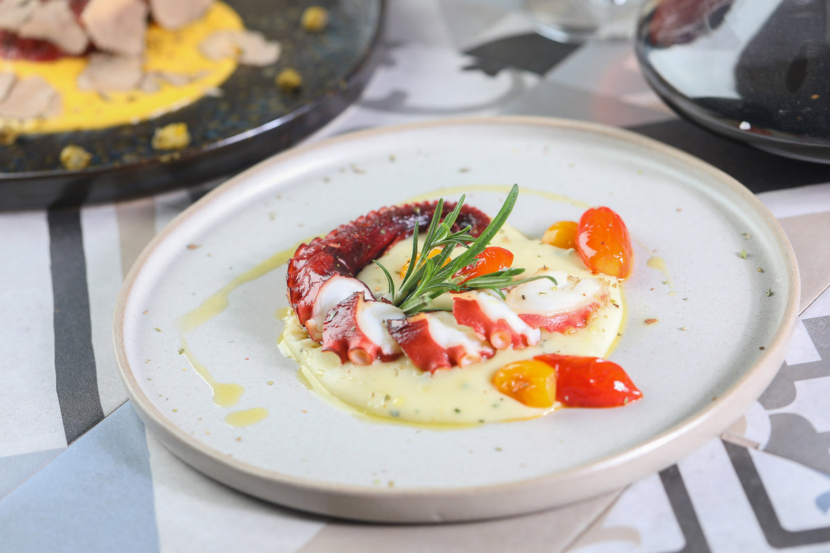 Grilled octopus on potato cream with cherry tomatoes at That's Amore