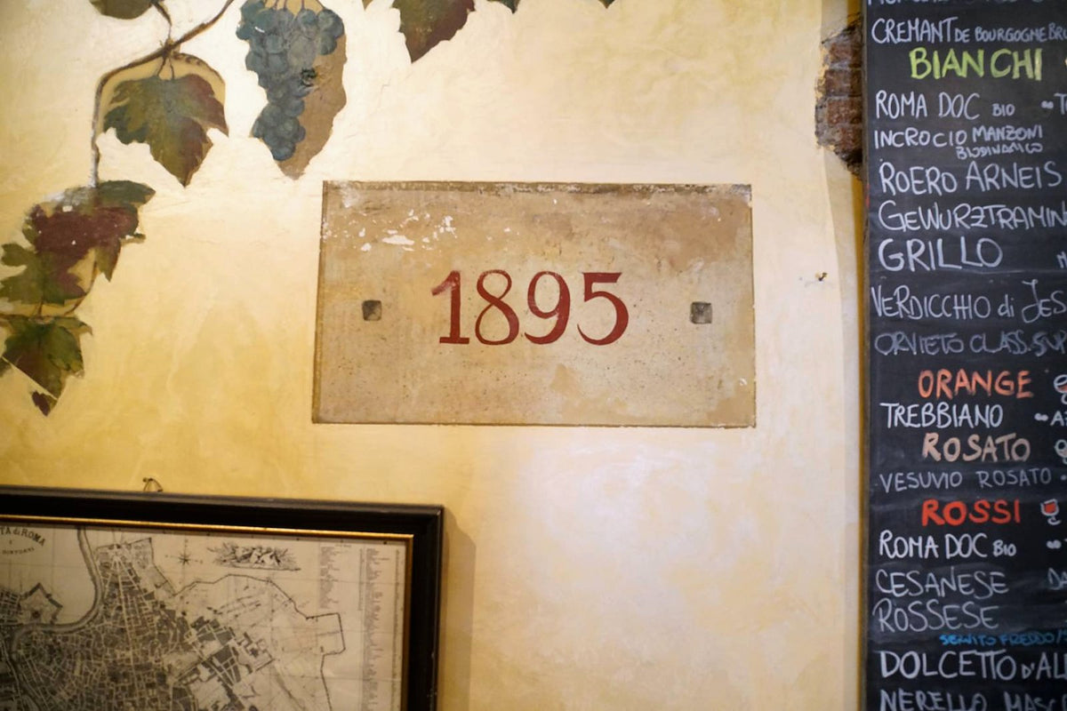 The 1895 plaque and the wine chalkboard inside Ai Tre Scalini