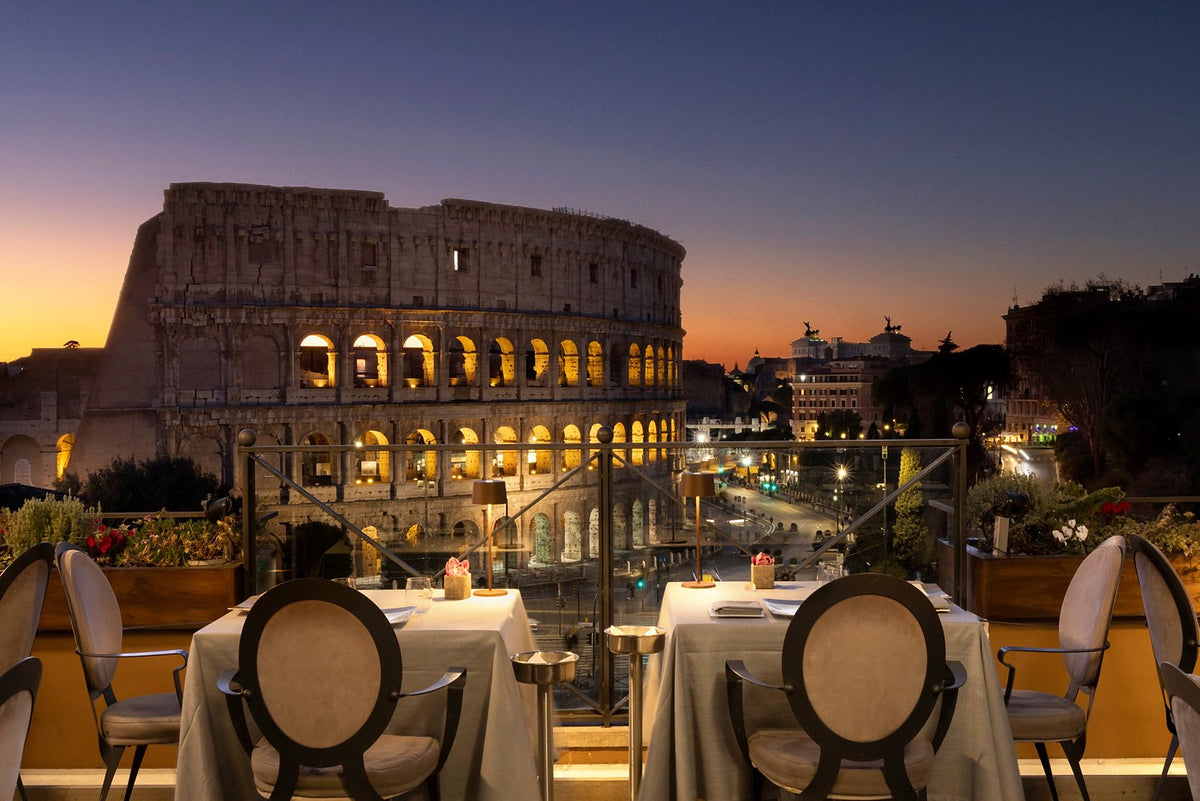 Aroma's rooftop terrace at dusk, facing the Colosseum