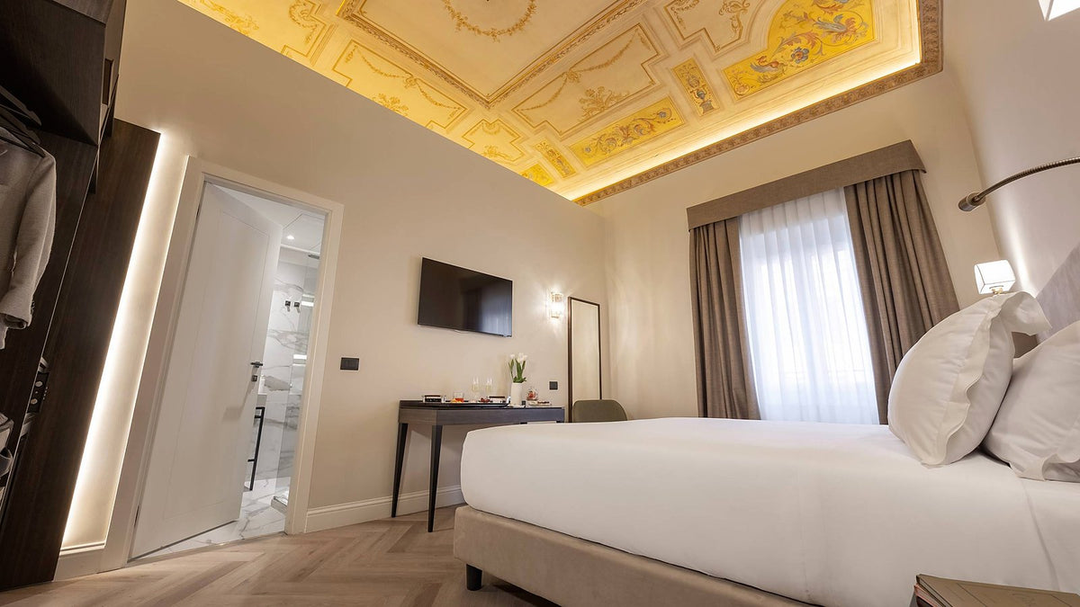 A double room beneath a decorated ceiling at BH Hotel Roma