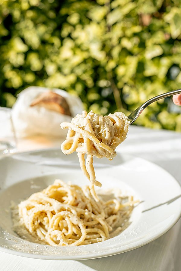 Pasta cacio e pepe twirled on a fork at Da Cesare al Casaletto