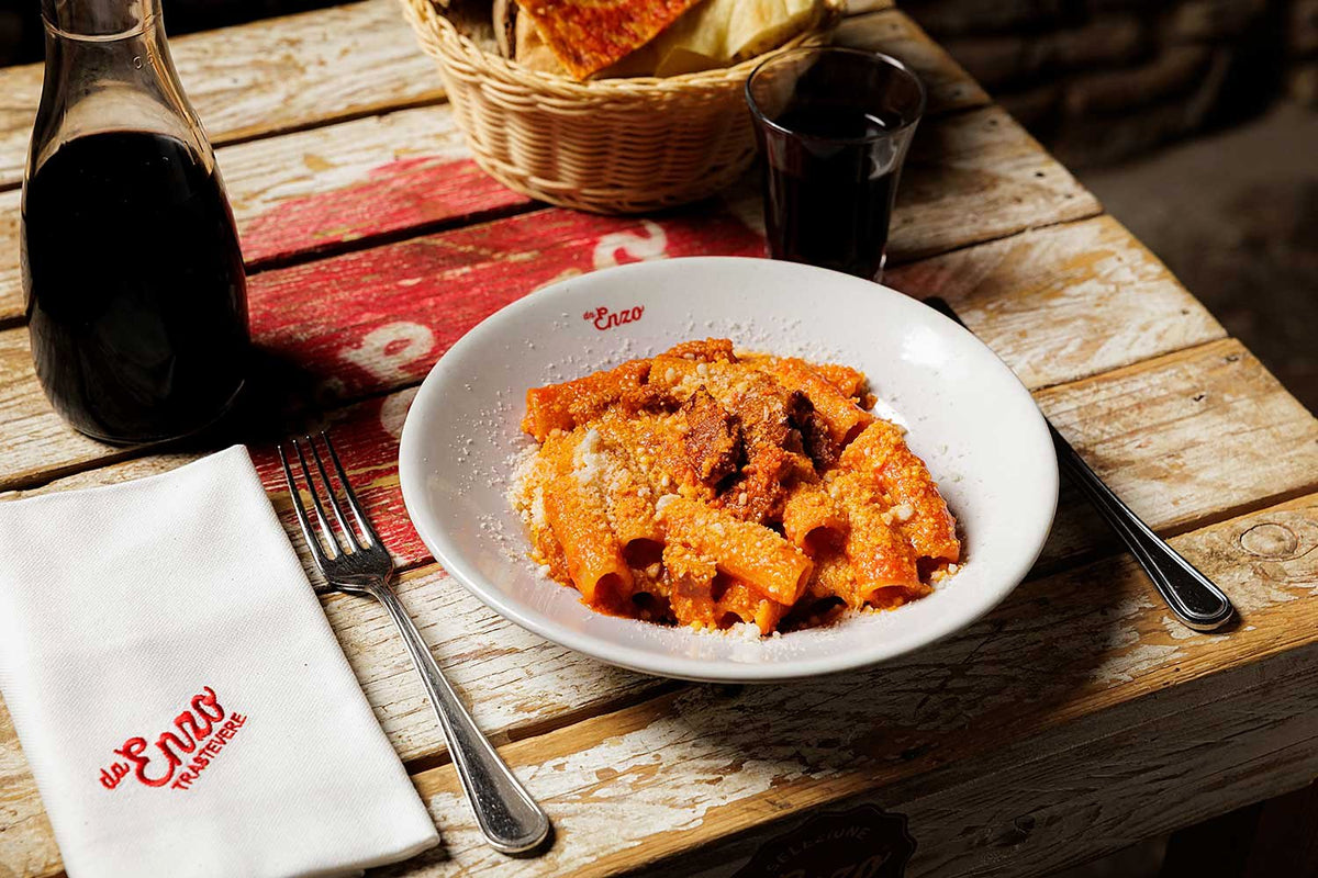 Pasta in tomato sauce with a carafe of red at Da Enzo al 29