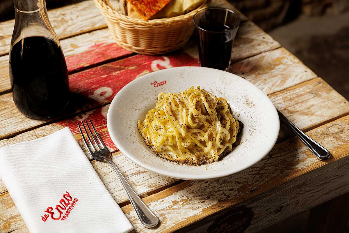 A plate of creamy Roman pasta on the wooden table at Da Enzo al 29