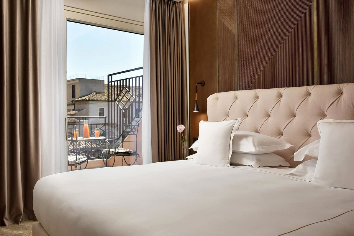 A suite bedroom opening onto a balcony at FH55 Grand Hotel Palatino