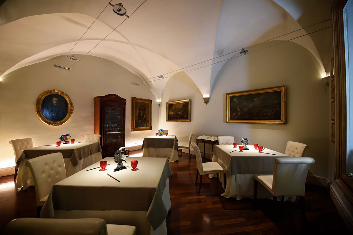 A vaulted dining room hung with paintings at Il Convivio Troiani