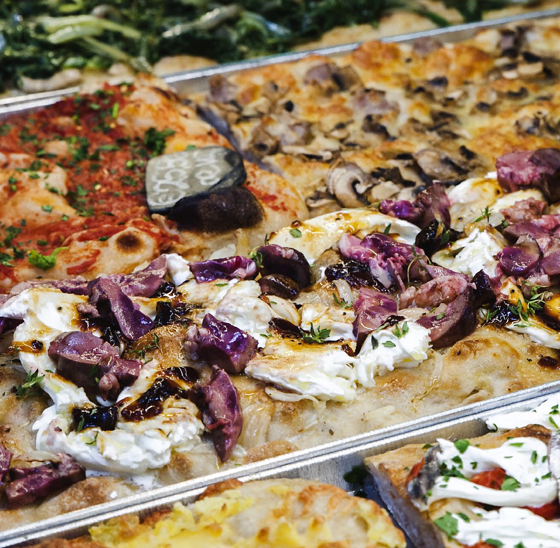 Trays of pizza al taglio by Bonci, the team behind Pizzarium