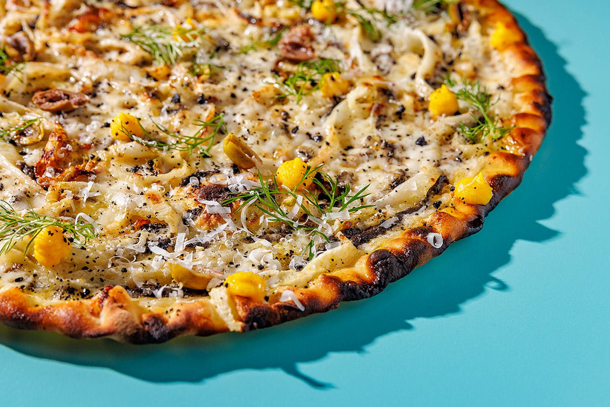 A pizza with a puffed, charred crust at Seu Pizza Illuminati