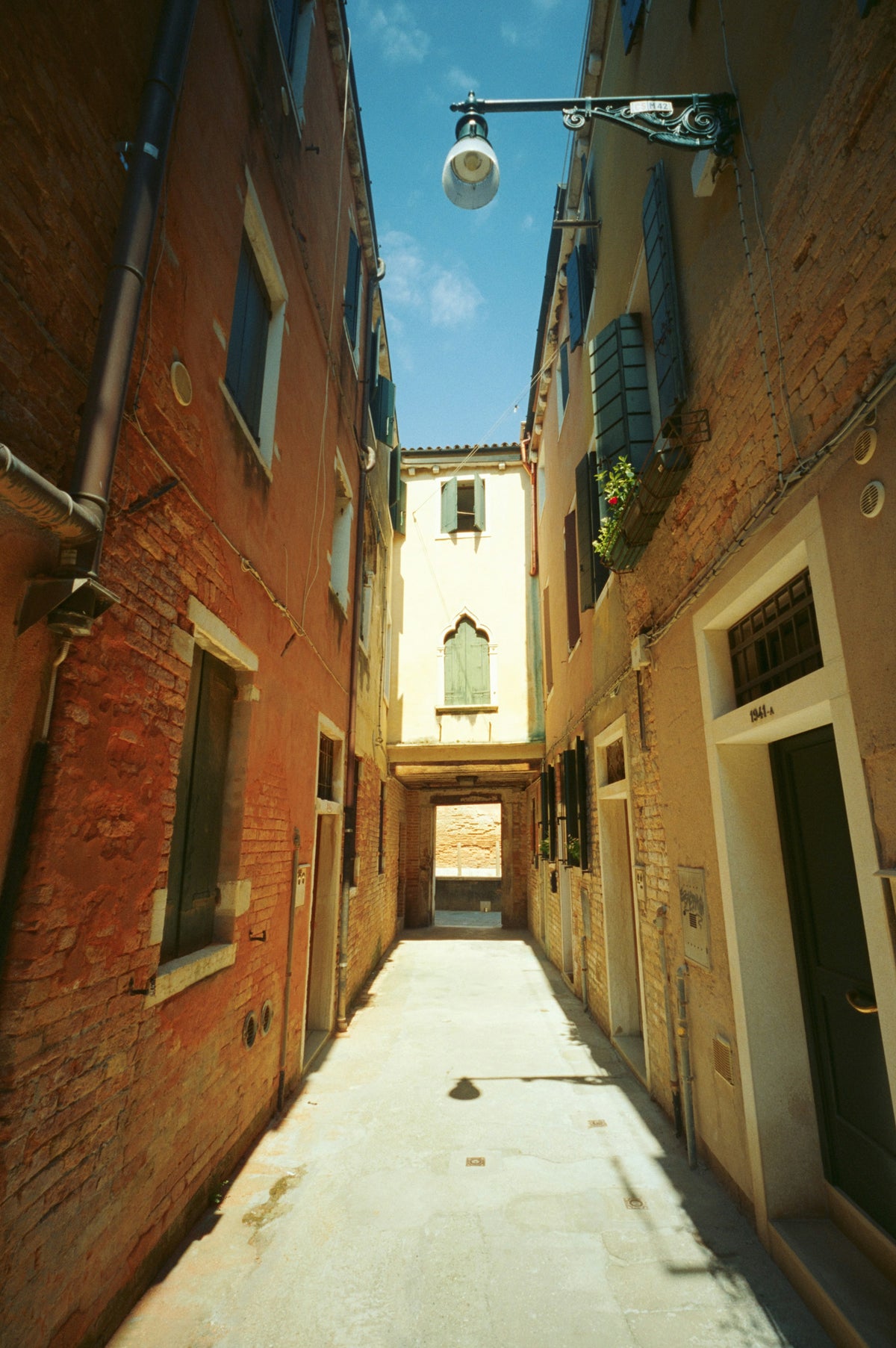 A sunlit calle between old brick houses in Cannaregio