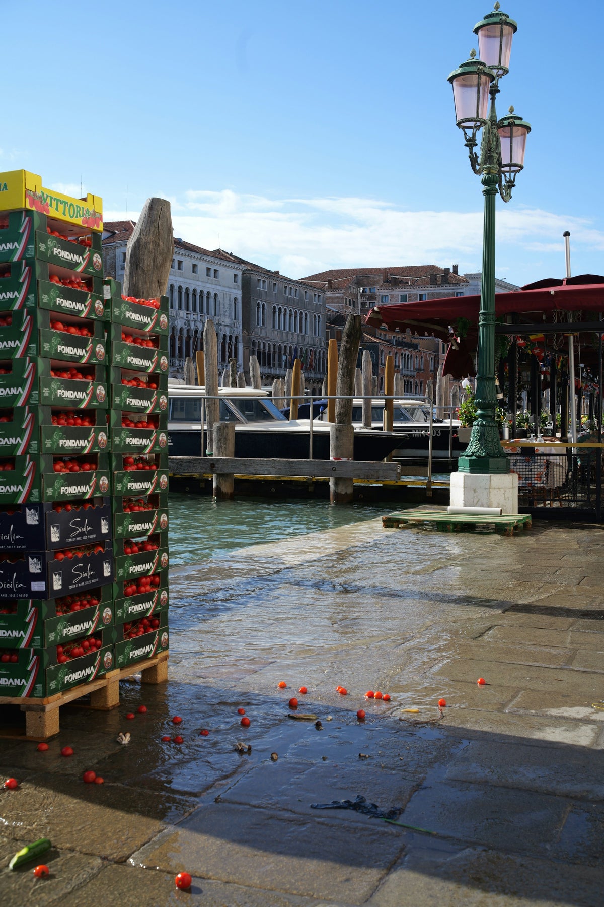 Crates of tomatoes delivered to a wet quay on the Grand Canal