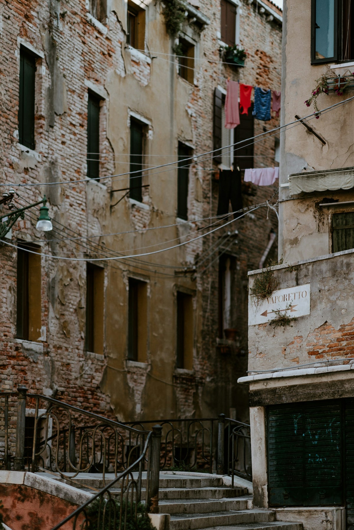 A weathered house with laundry and a hand-painted vaporetto sign