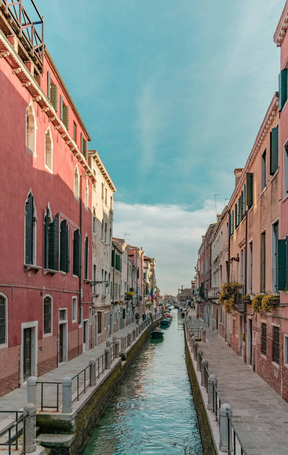 A long straight canal flanked by fondamente and pastel houses