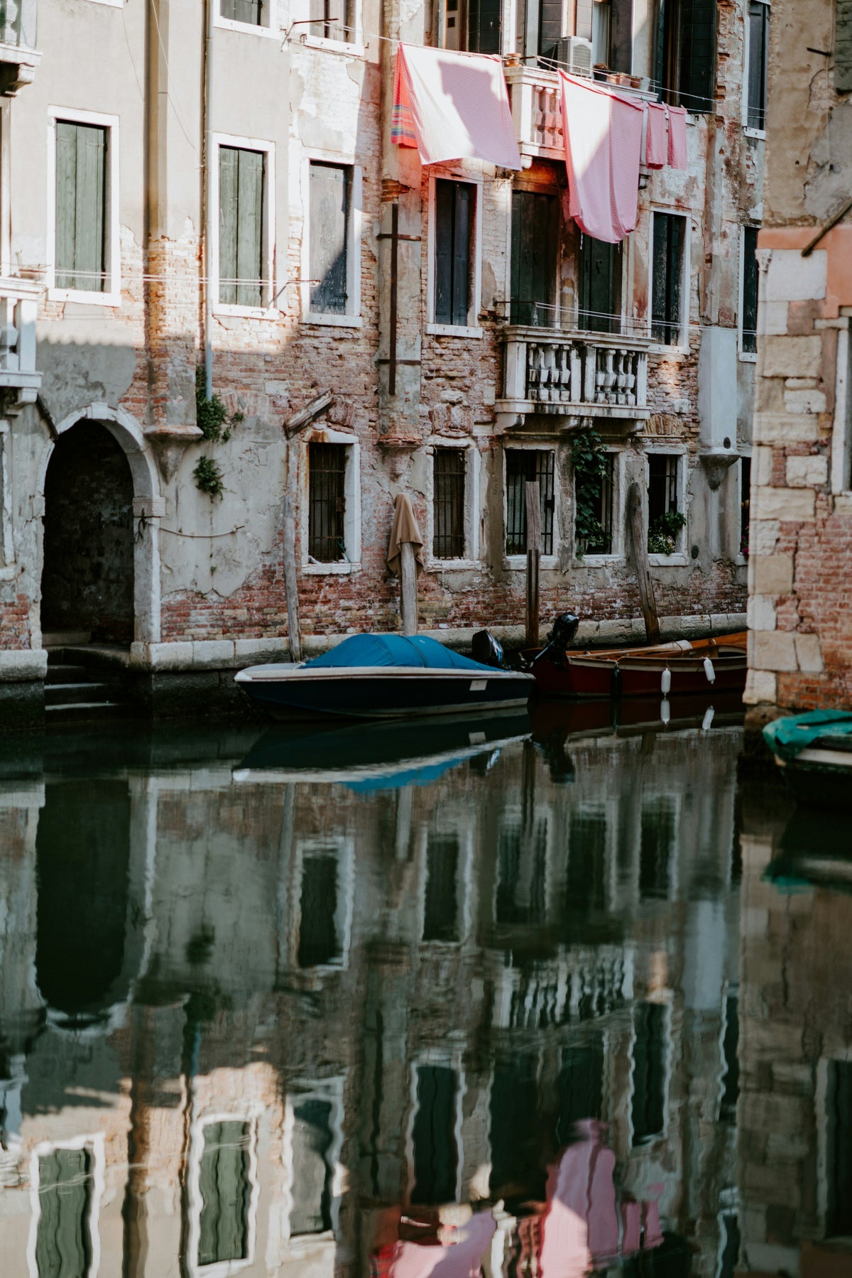 Laundry drying above a quiet canal with moored boats
