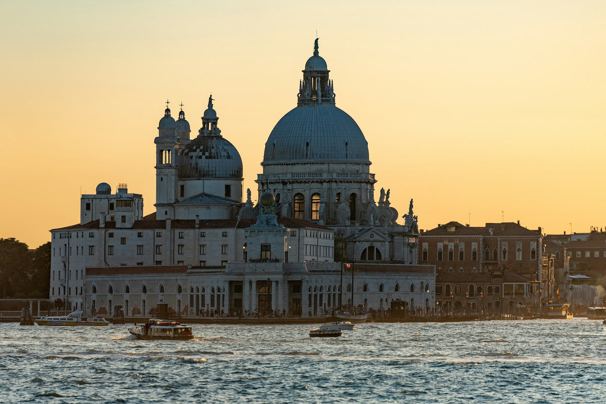 Santa Maria della Salute silhouetted against a golden sunset sky