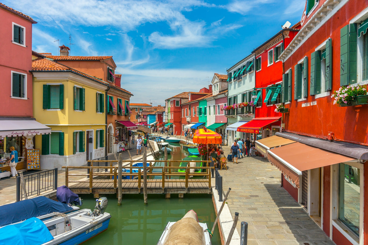 Colourful houses, shops and boats along a canal on Burano