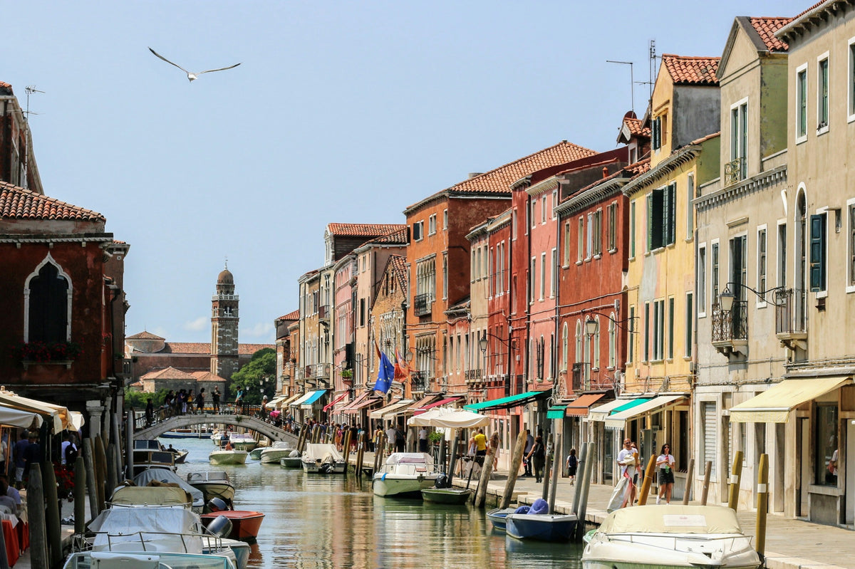 A canal lined with colourful houses and moored boats on Murano