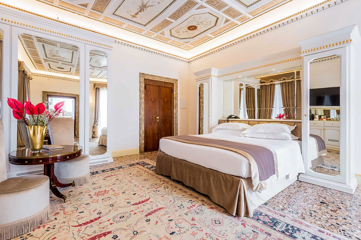 Bright junior suite with stuccoed ceiling, double bed and mirrored wardrobes