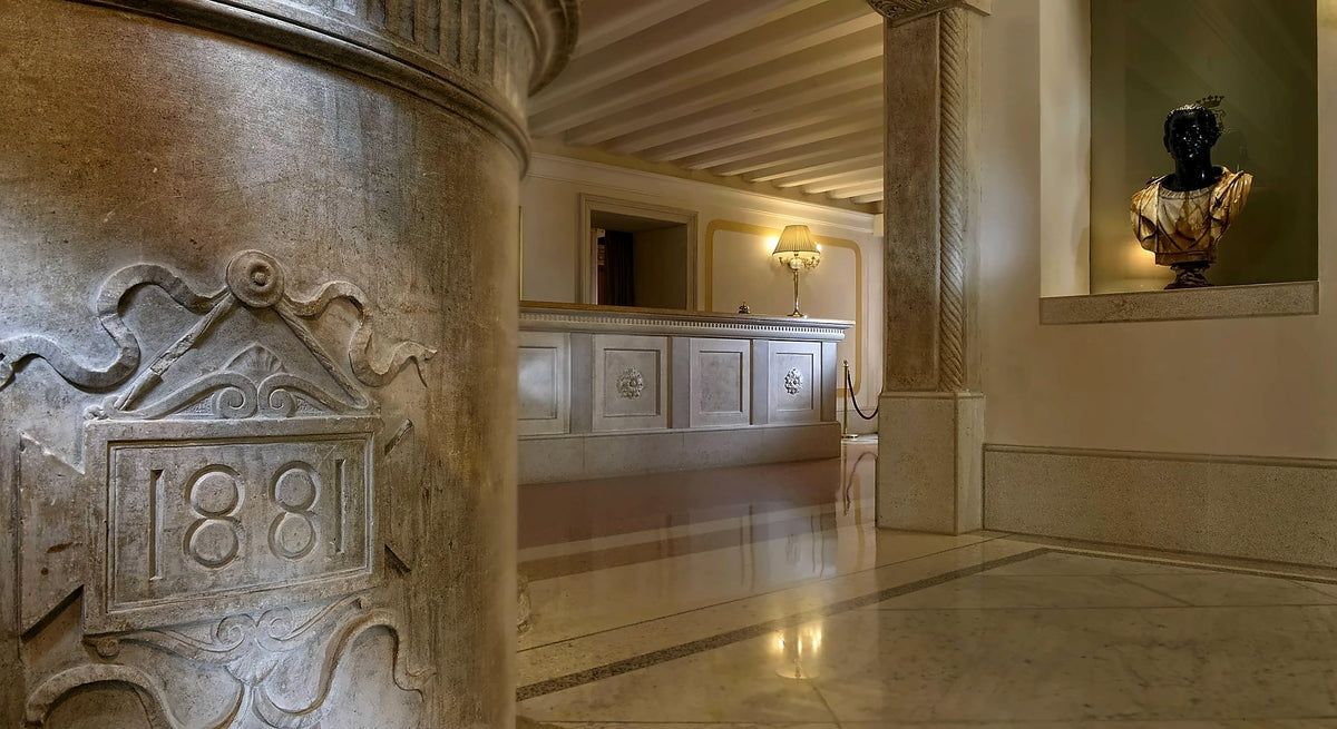 Marble lobby with a carved column dated 1881 and the reception desk