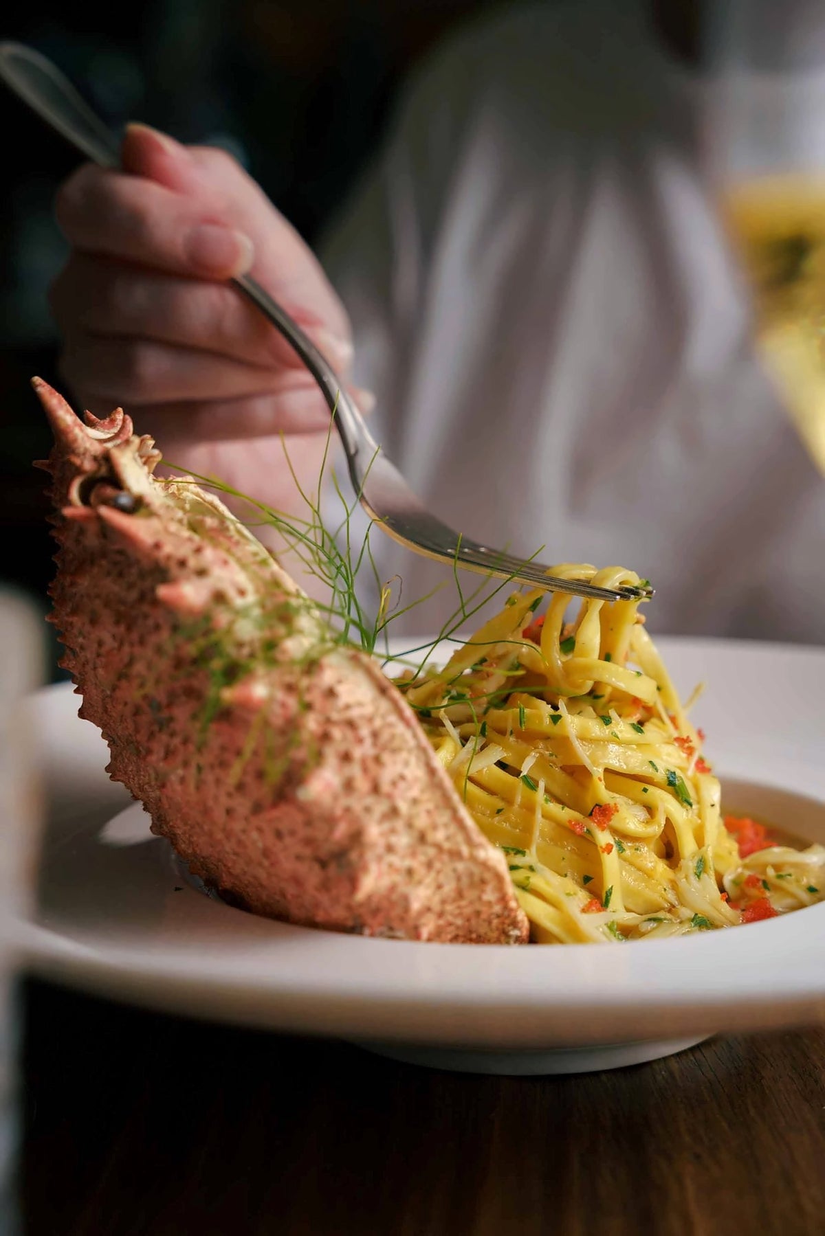 Lobster with tagliolini pasta on a white plate