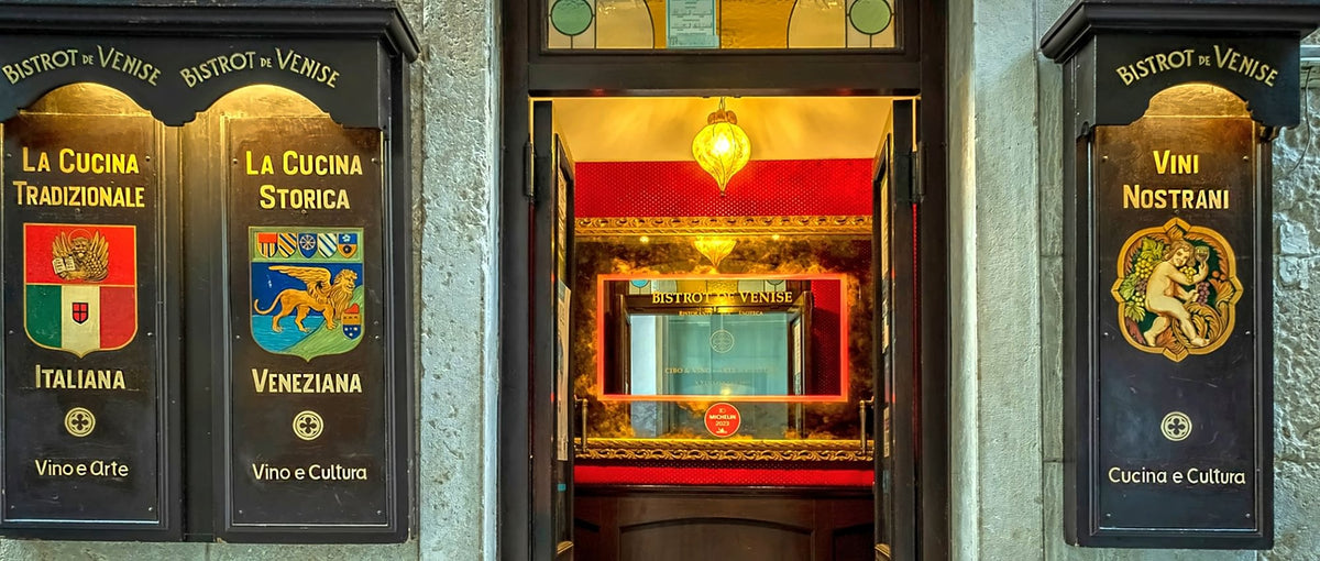 Entrance with painted signboards and a warmly lit window