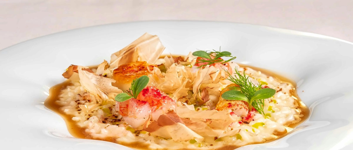 Creamy risotto topped with shellfish, crisp pastry shards and herbs