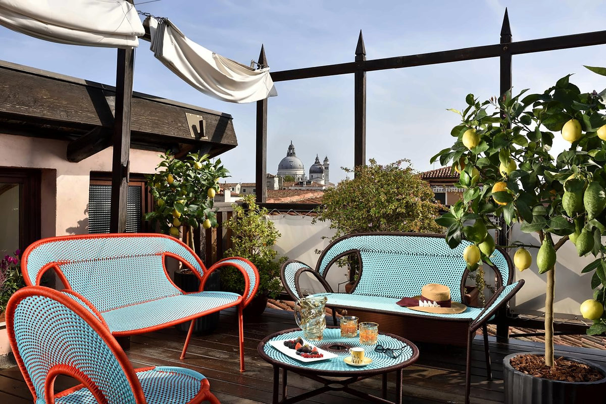 Rooftop altana with colourful wicker seats, lemon trees and the Salute dome