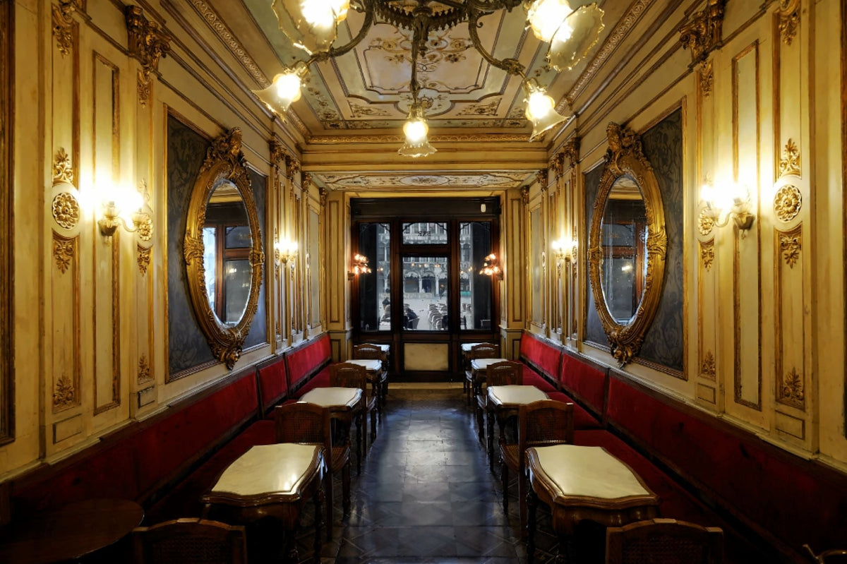 Gilded Sala delle Stagioni with oval mirrors, red benches and marble tables