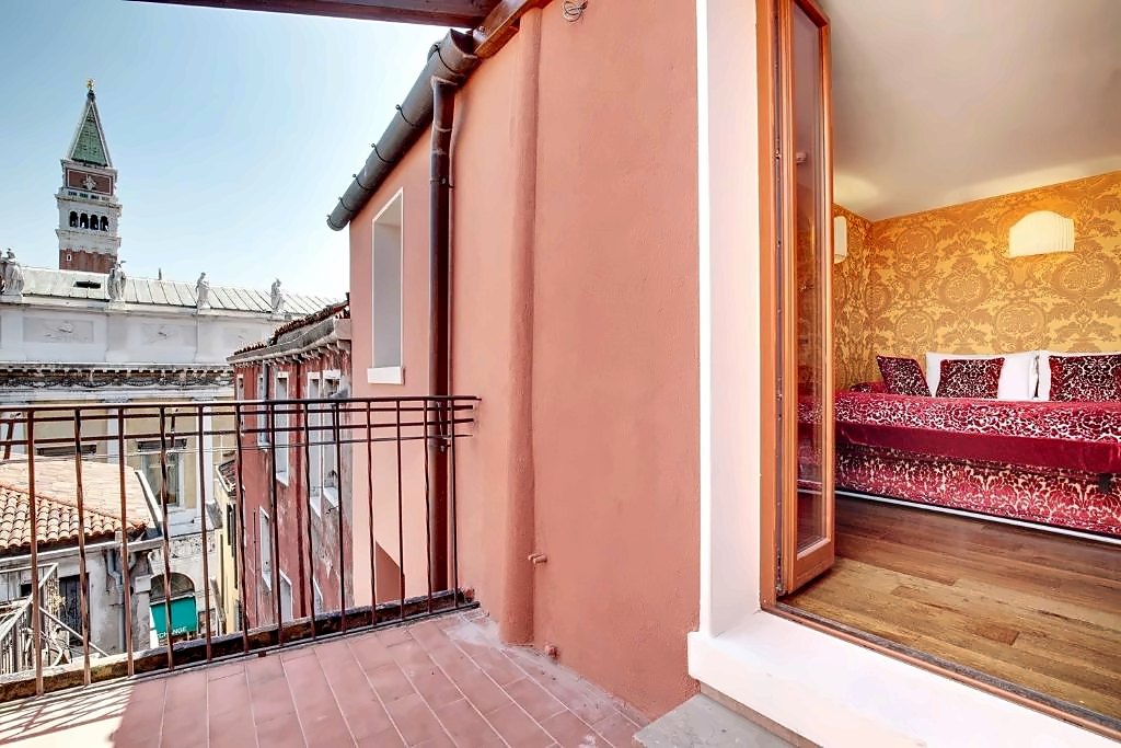 Balcony room with red damask bed and a view of St Mark's bell tower